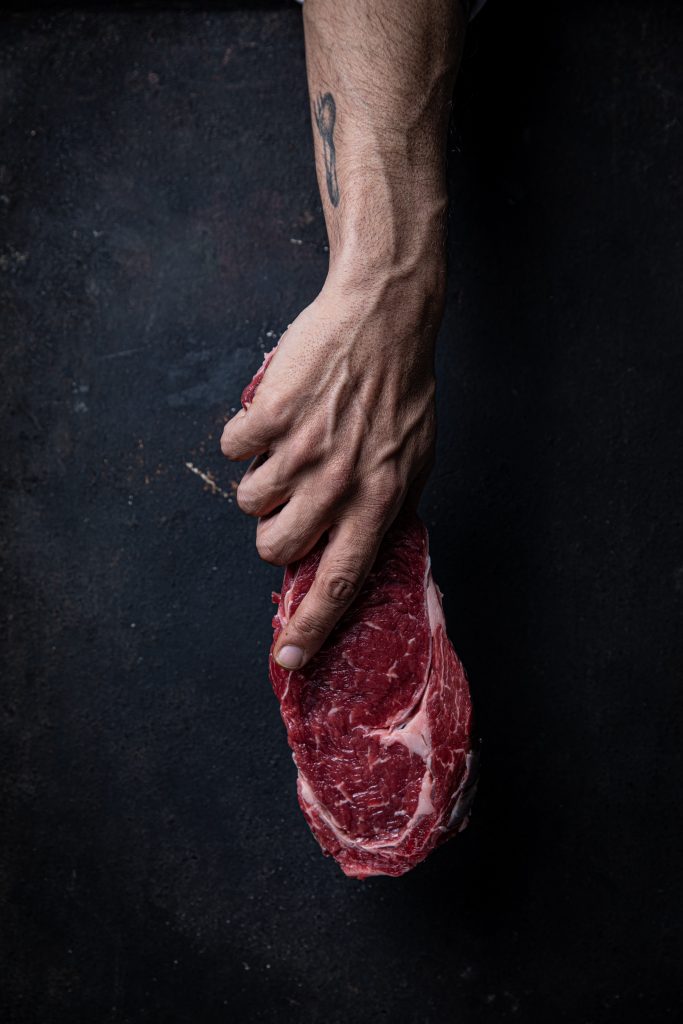 תמונה של שף מחזיק בבשר טרי